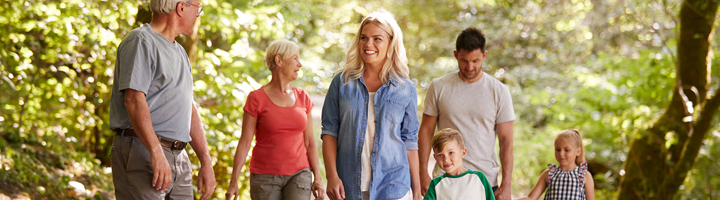 Multi Generation Family Enjoying Walk Along Woodland Path Together